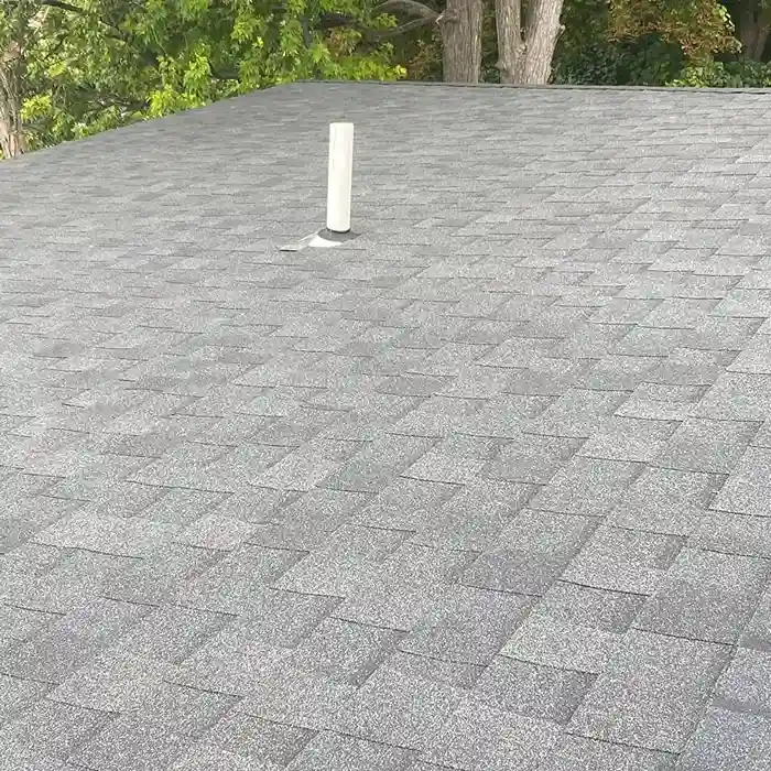 A close-up view of an asphalt shingle roof featuring a vent installed to improve attic ventilation and prevent moisture buildup.